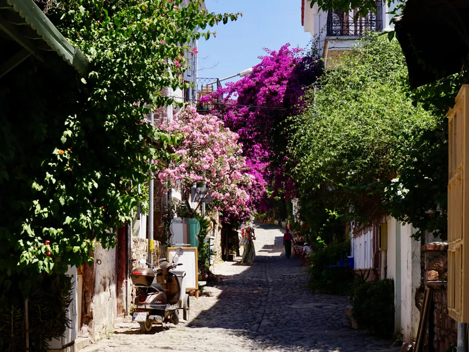 Malerische Gassen mit blühenden Bougainvilleen sind  typisch für historische Orte an der türkischen Ägäis.