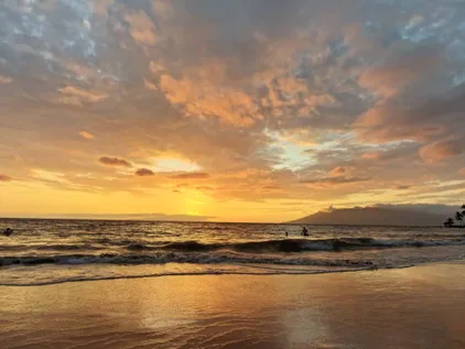 Abendstimmung auf Hawaii: Die Sonne versinkt hinter dem Meer und taucht die Inseln in warmes Licht.