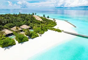 Paradiesischer Strand auf den Malediven mit Palmen und kristallklarem Wasser