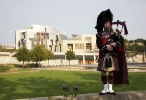 Ein Dudelsackspieler vor dem Schottischen Parlamentsgebäude in Holyrood, Edinburgh