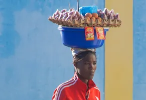 Straßenhändlerin, die ihre Waren auf dem Kopf trägt